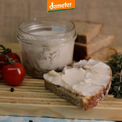 Holzbrett mit Kuhhorster Schweineschmalz im Glas, Tomanten und Brot