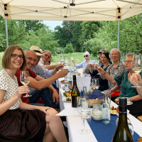 Gruppe von Gästen bei der Weinvesper auf dem Königlichen Weinberg unter einem Pavillon