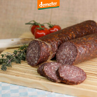 Kuhhorster Rindersalami im Stück und in Scheiben geschnitten auf Holzbrett